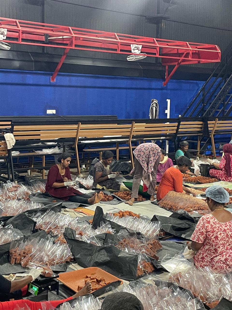Team portioning jaggery cubes into packs